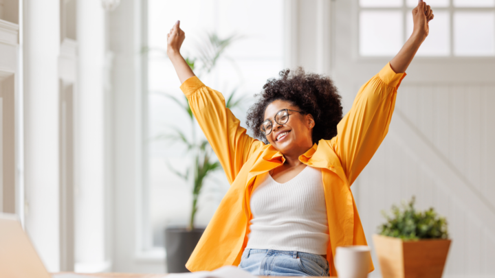 Woman celebrating success in work wearing bright orange shirt